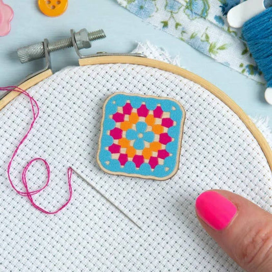 A wooden granny square magnetic needle minder from Hawthorn Handmade on a cross stitch hoop.