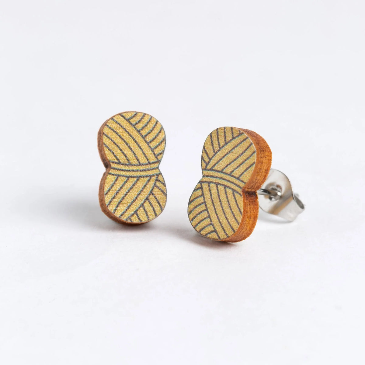 A pair of wooden stud earrings shaped like balls of wool, in Mustard, set against a plain white background.