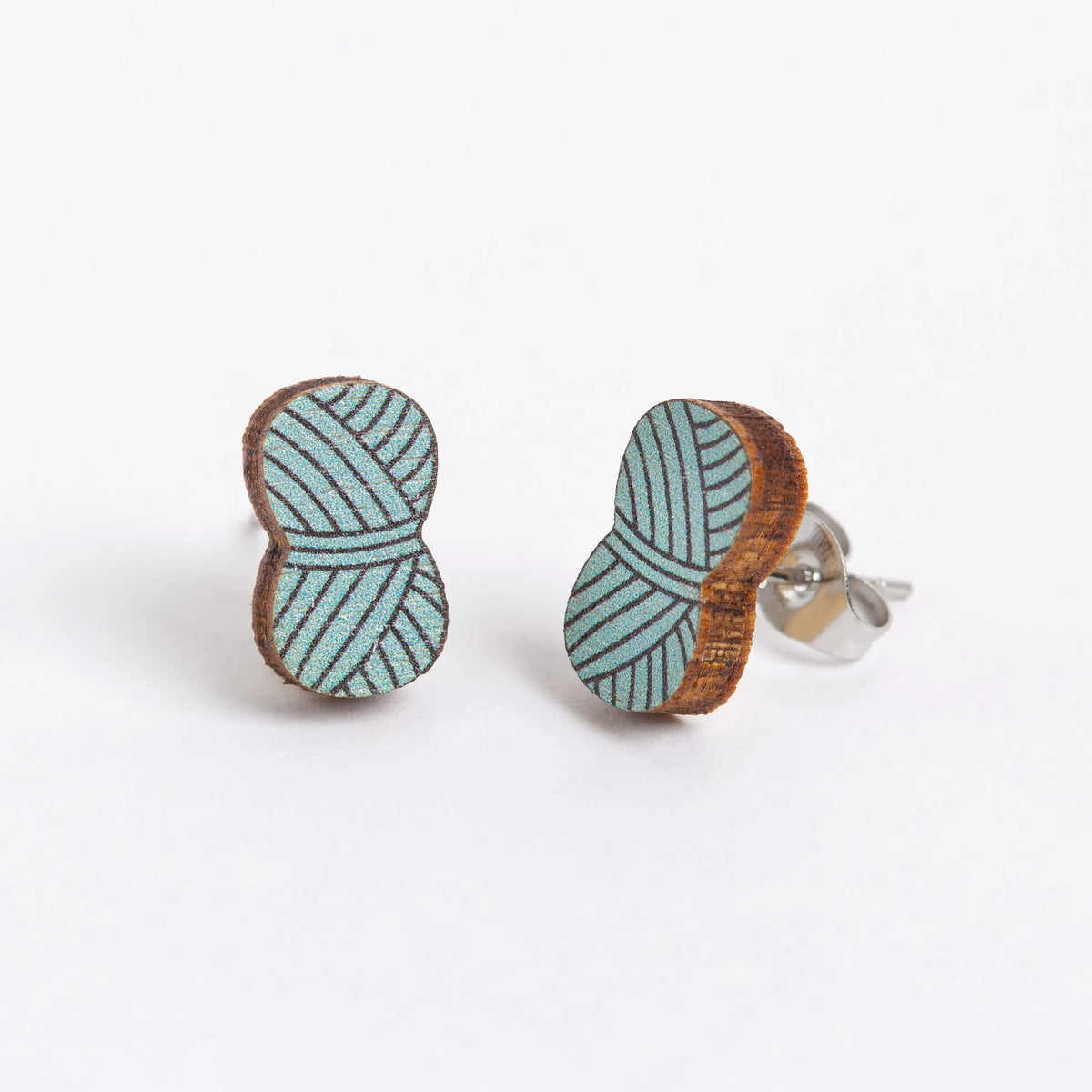 Pair of yarn ball earrings in Teal on a white background.