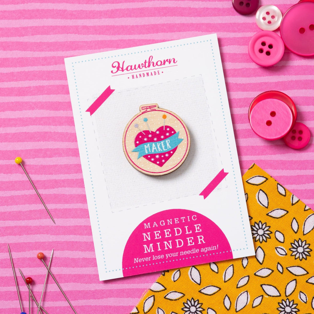 Magnetic needle minder on a Hawthorn Handmade card with buttons and fabric on a pink background
