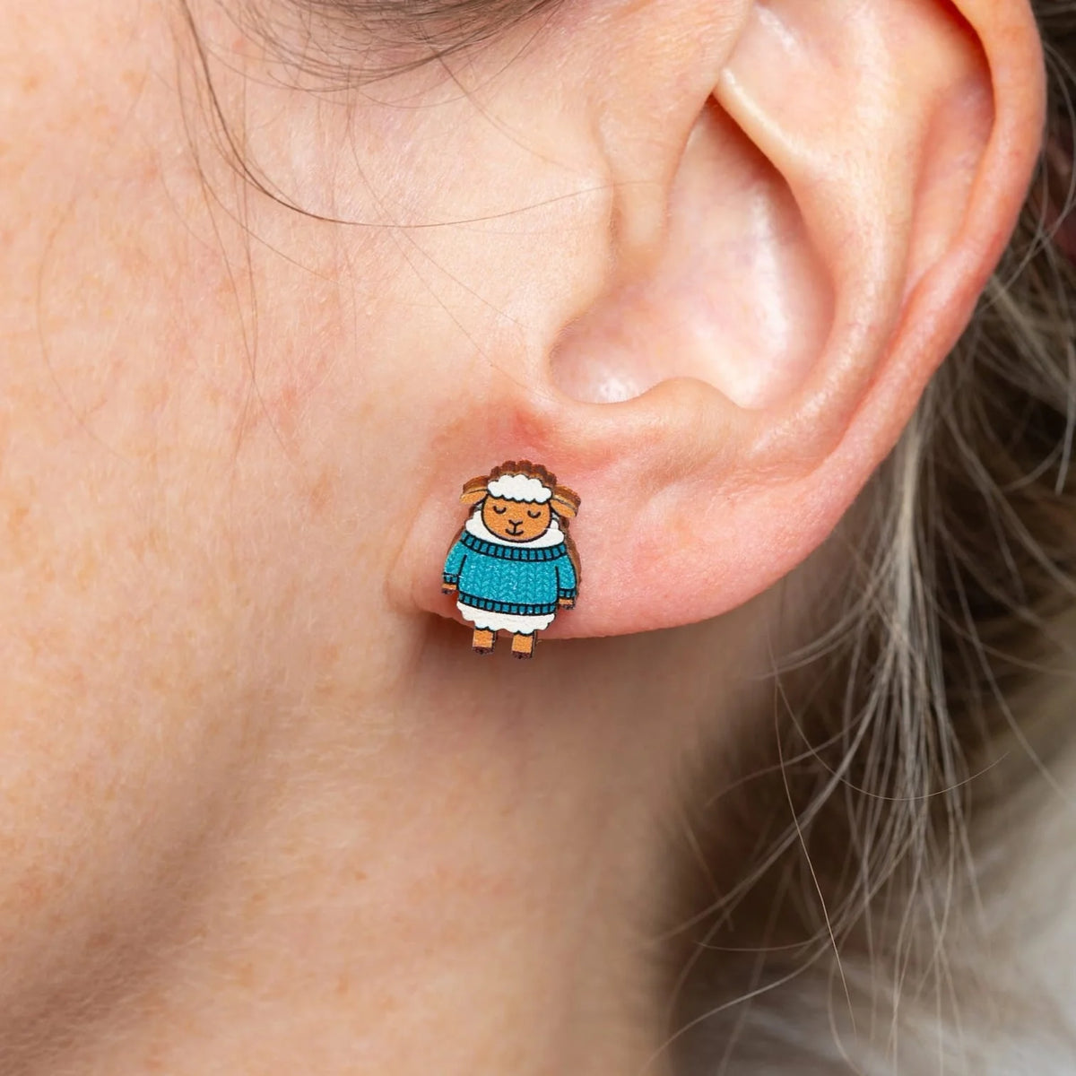 Earring with a woolly sheep design from Hawthorn Handmade, worn on an ear.