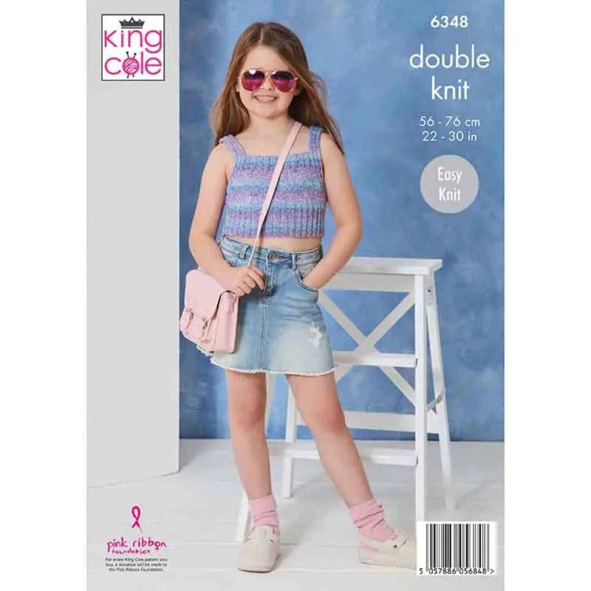 Knitting pattern with a child wearing a knitted top and denim skirt. The pattern is rom King Cole and is double knit pattern, 6348.
