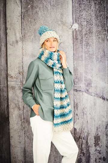 Striped bobble hat and long scarf. Both striped with a pale cream, light and darker blue. 
