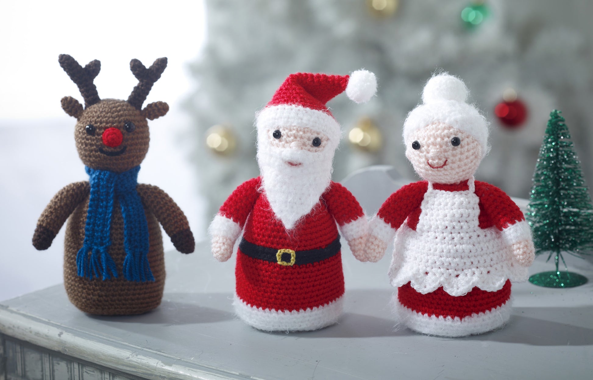 Adorable little decorative characters of Santa, Mrs Claus and Rudolph with a blue scarf. Each figure is approximately 18cm tall.